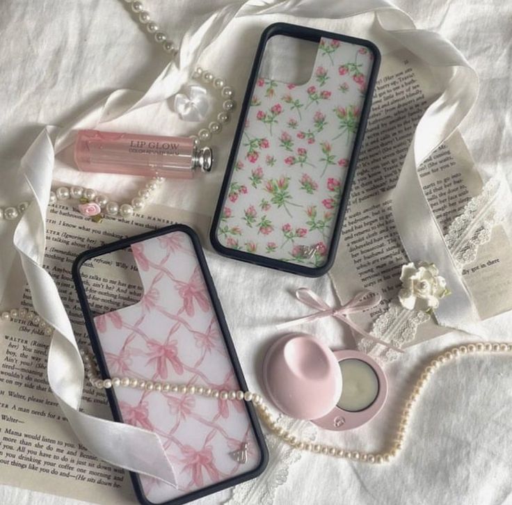 three cell phones sitting next to each other on top of a white cloth covered table