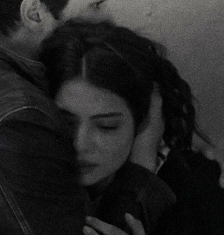 a man and woman embracing each other in black and white