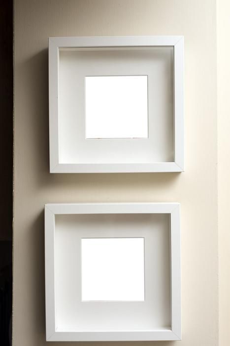 two white square frames mounted on the wall