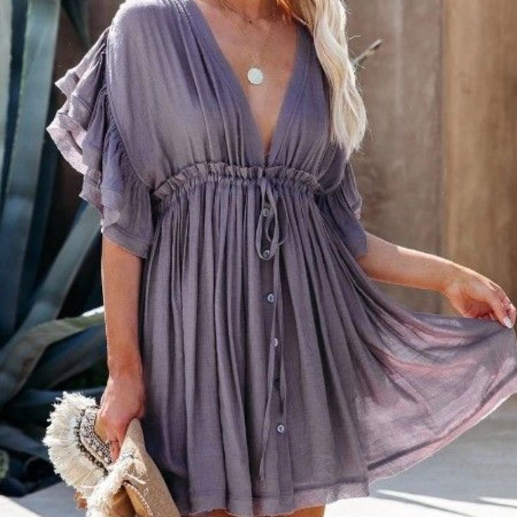 This Beautiful Dress Features A Lavender Color With A Lightweight Fabric. It Has Pockets And Faux Buttons Up The Front And An Adjustable Tie For The Waist And Neck Billowy Short Sleeve Mini Dress For Summer, Purple V-neck Dress With Ruffle Hem, Billowy Mini Dress For Summer, Summer Beach Dress With Butterfly Sleeves, Summer Beach Dresses With Butterfly Sleeves, Billowy Ruffled Mini Dress For Summer, Flowy Lavender Mini Dress For Spring, Lavender Flowy Mini Dress For Spring, Bohemian Summer Dresses With Ruffle Sleeves