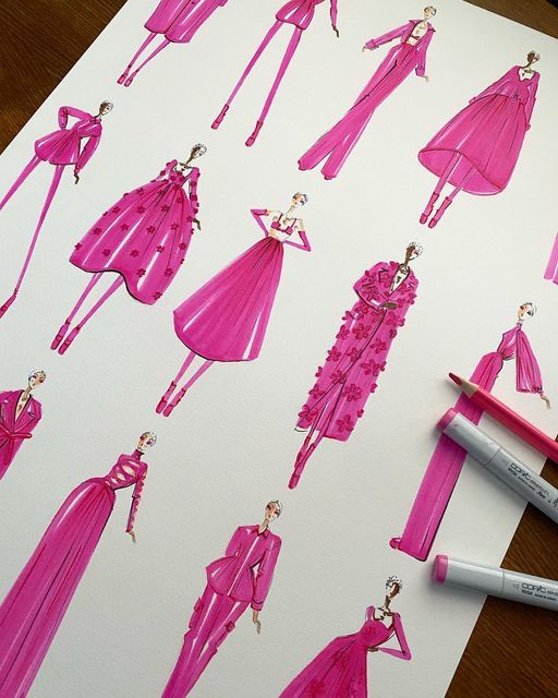 a drawing of a pink dress on paper next to some markers and pencils,