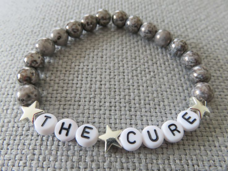 a beaded bracelet with the word'the cure'written in white letters on it