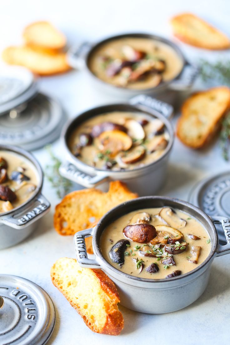 several bowls of soup with bread on the side