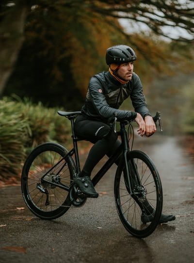 a man riding a bike down a wet road