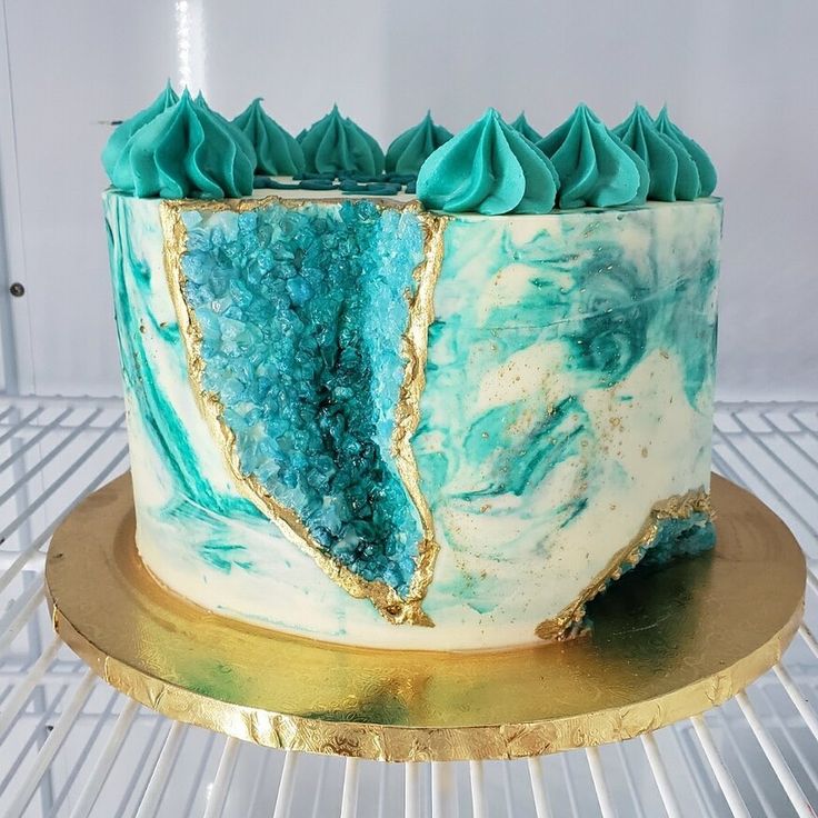 a blue and white cake sitting on top of a metal rack