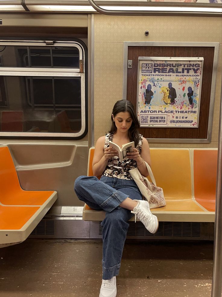 a woman sitting on a train reading a book