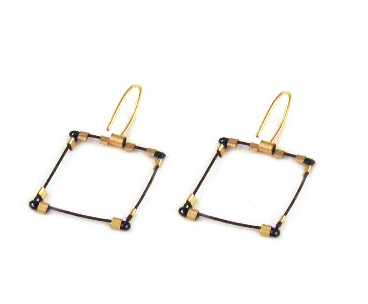 two square shaped gold and black beads are hanging from the ends of earwires