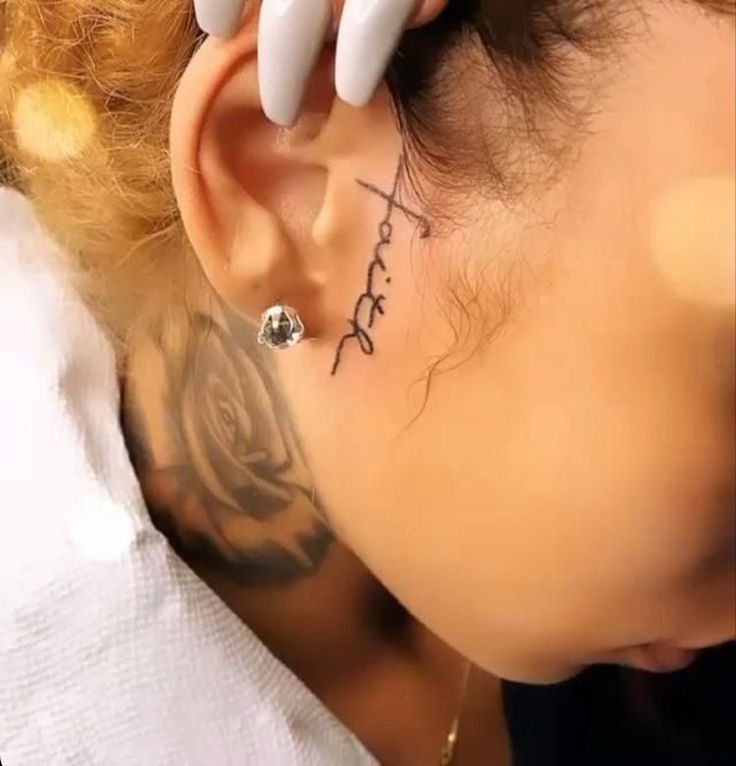 a woman with tattoos on her neck and behind her ear