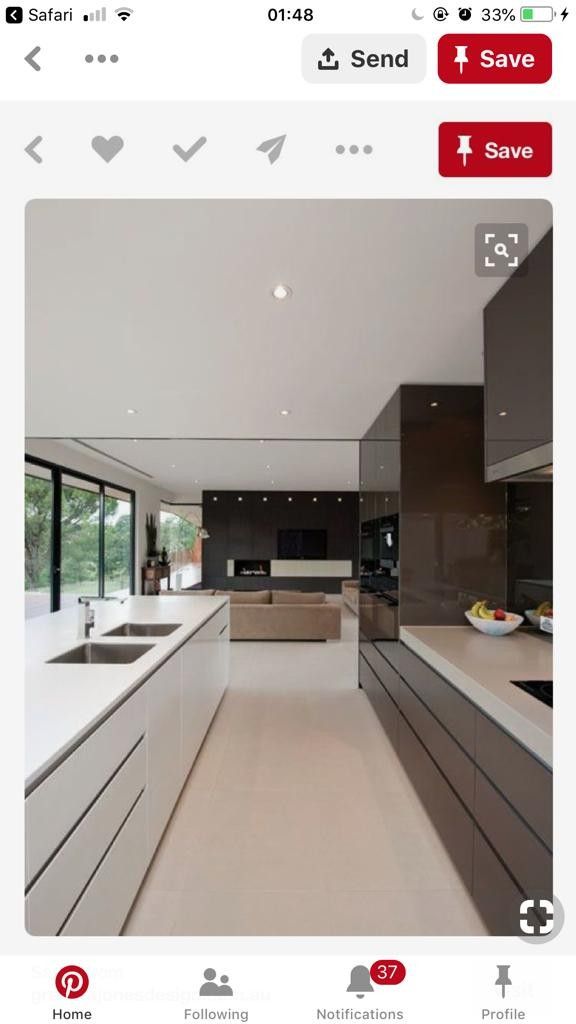 a modern kitchen with white counter tops and brown cabinetry, along with large windows