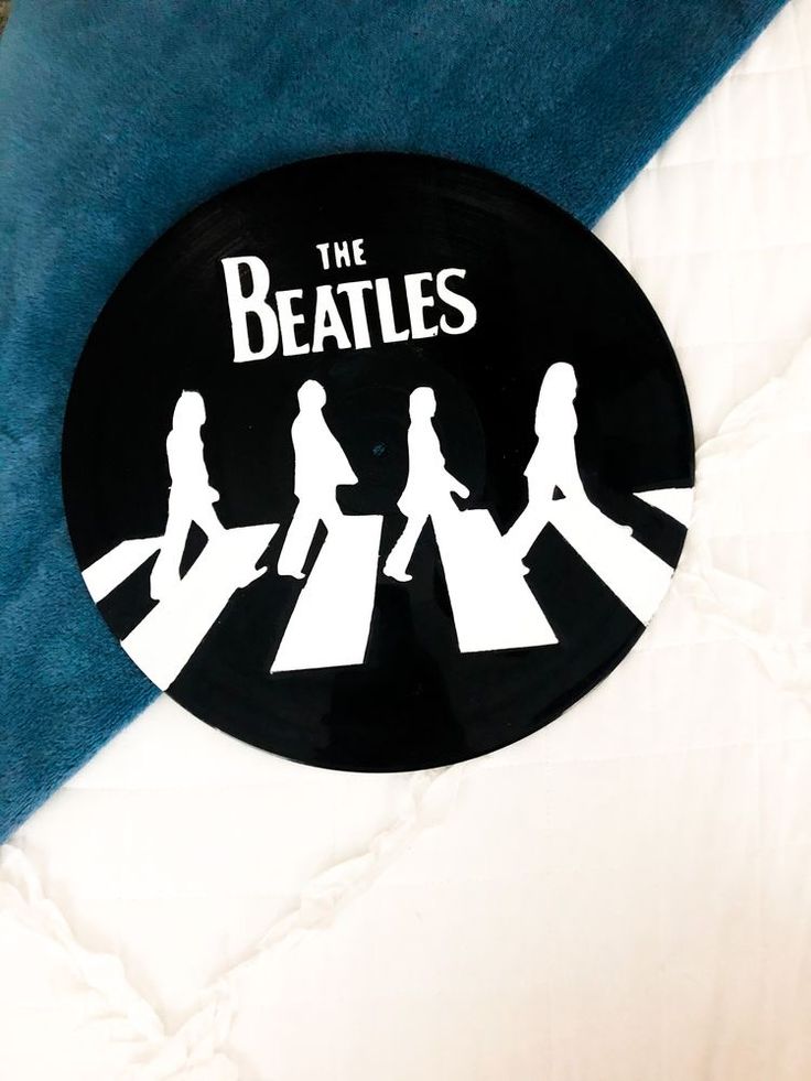 the beatles sticker is sitting on top of a blue and white bedding sheet