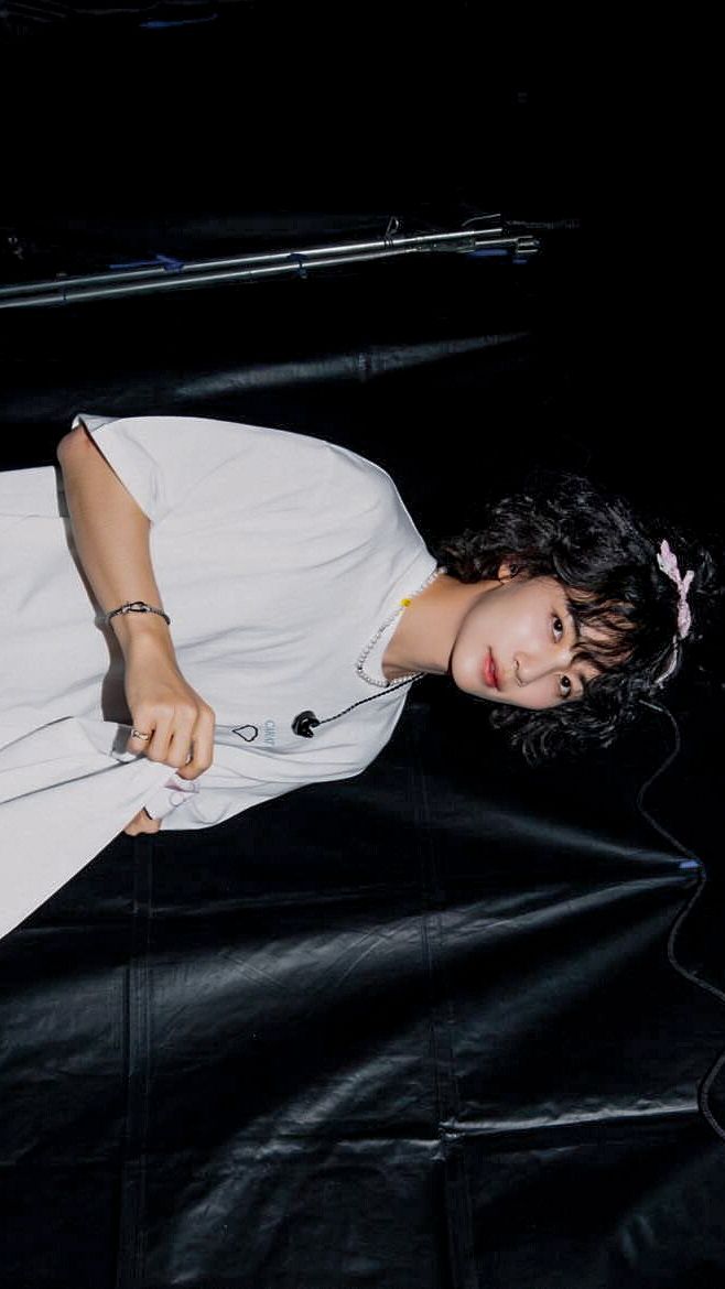 a young woman laying on top of a black leather floor next to a laptop computer