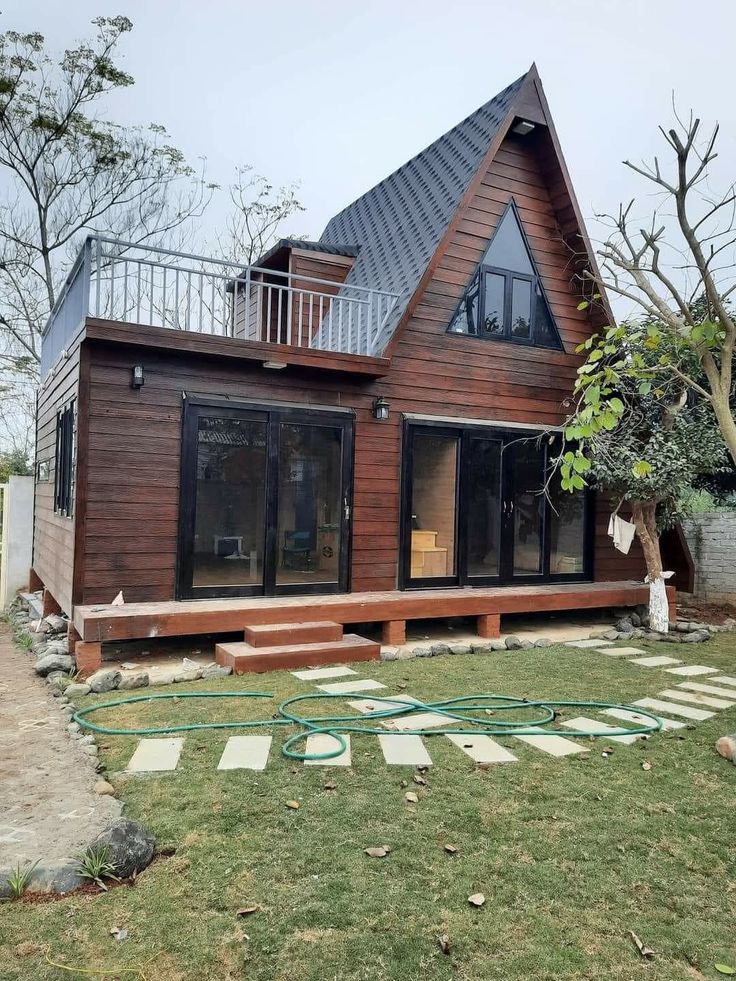 a large wooden house sitting on top of a lush green field