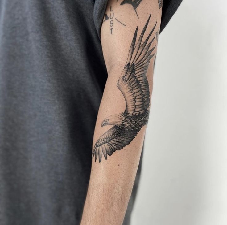 a man with a bird tattoo on his arm