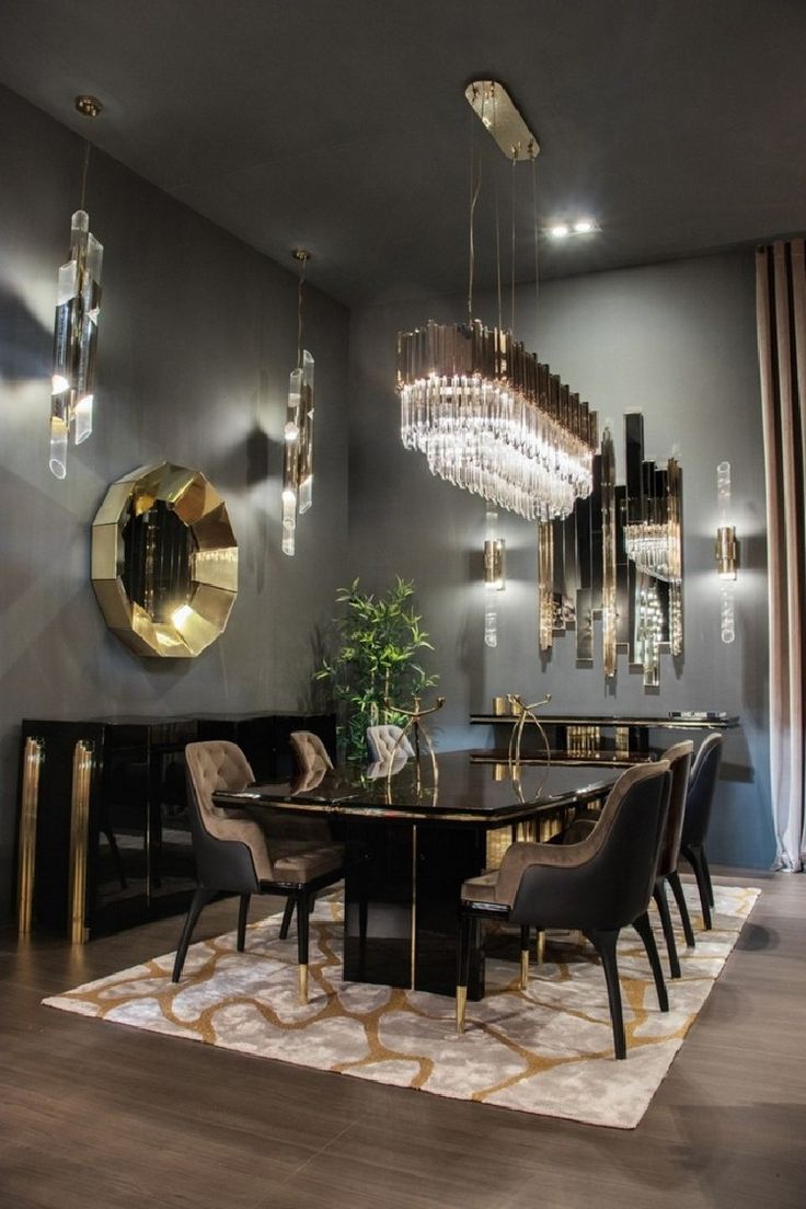 an elegant dining room with chandelier and black table surrounded by chairs in front of a large mirror