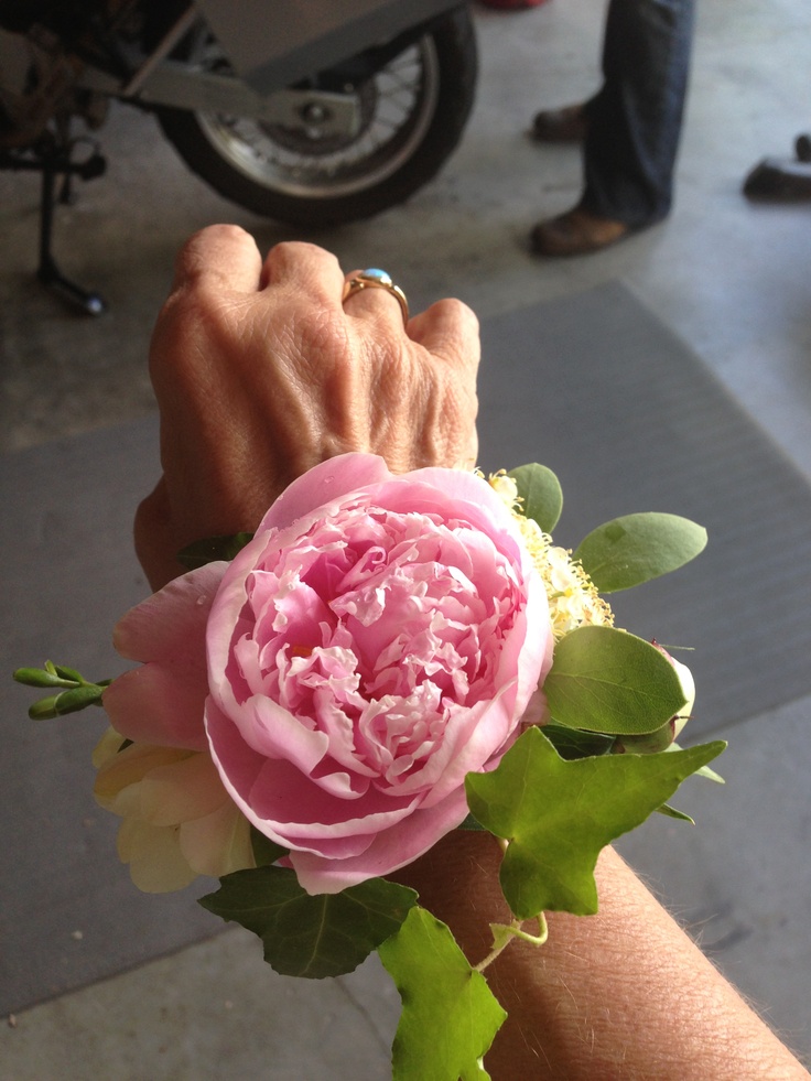 a person's arm with a pink flower on it and a motorcycle in the background