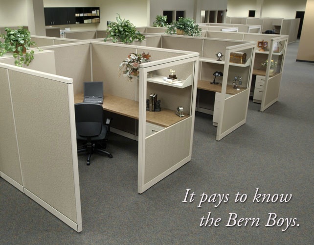 an office cubicle with plants on the desks and shelves in front of it