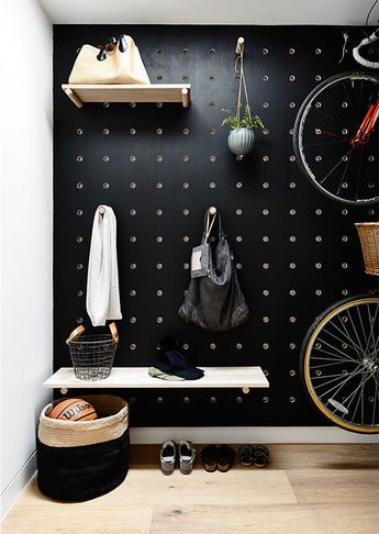 a bicycle is hanging on the wall next to a shelf with shoes and other items