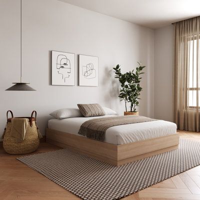 a bed sitting in a bedroom on top of a wooden floor next to a window