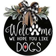 a black and white sign with a dog's paw on it that says welcome we hope you like dogs