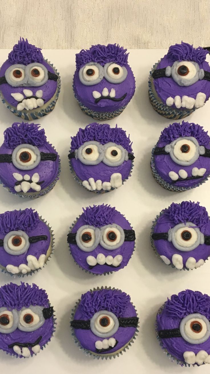 twelve purple cupcakes with white frosting decorated like minion faces and eyes