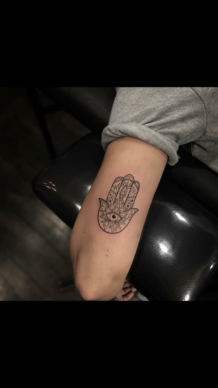 a person with a tattoo on their arm that has a hamsa hand in it