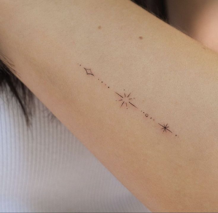 a woman's arm with a small star tattoo on the back of her shoulder