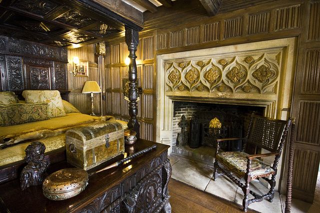 a bedroom with a bed, chair and fire place in the middle of the room