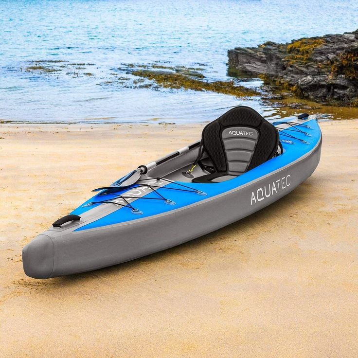 a blue and gray kayak sitting on top of a sandy beach