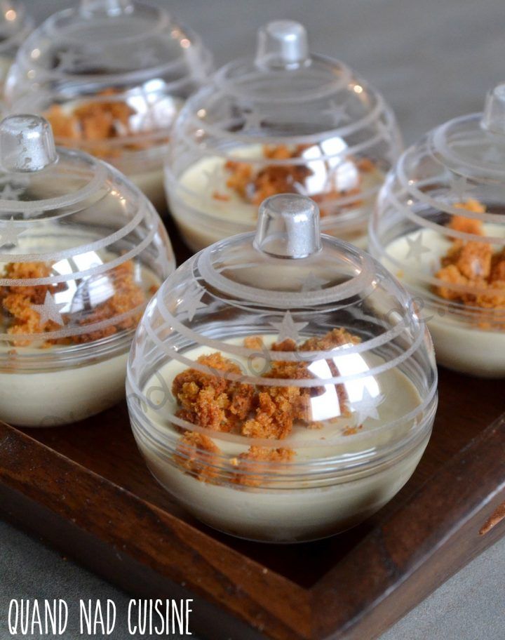 several desserts in glass containers sitting on a wooden tray