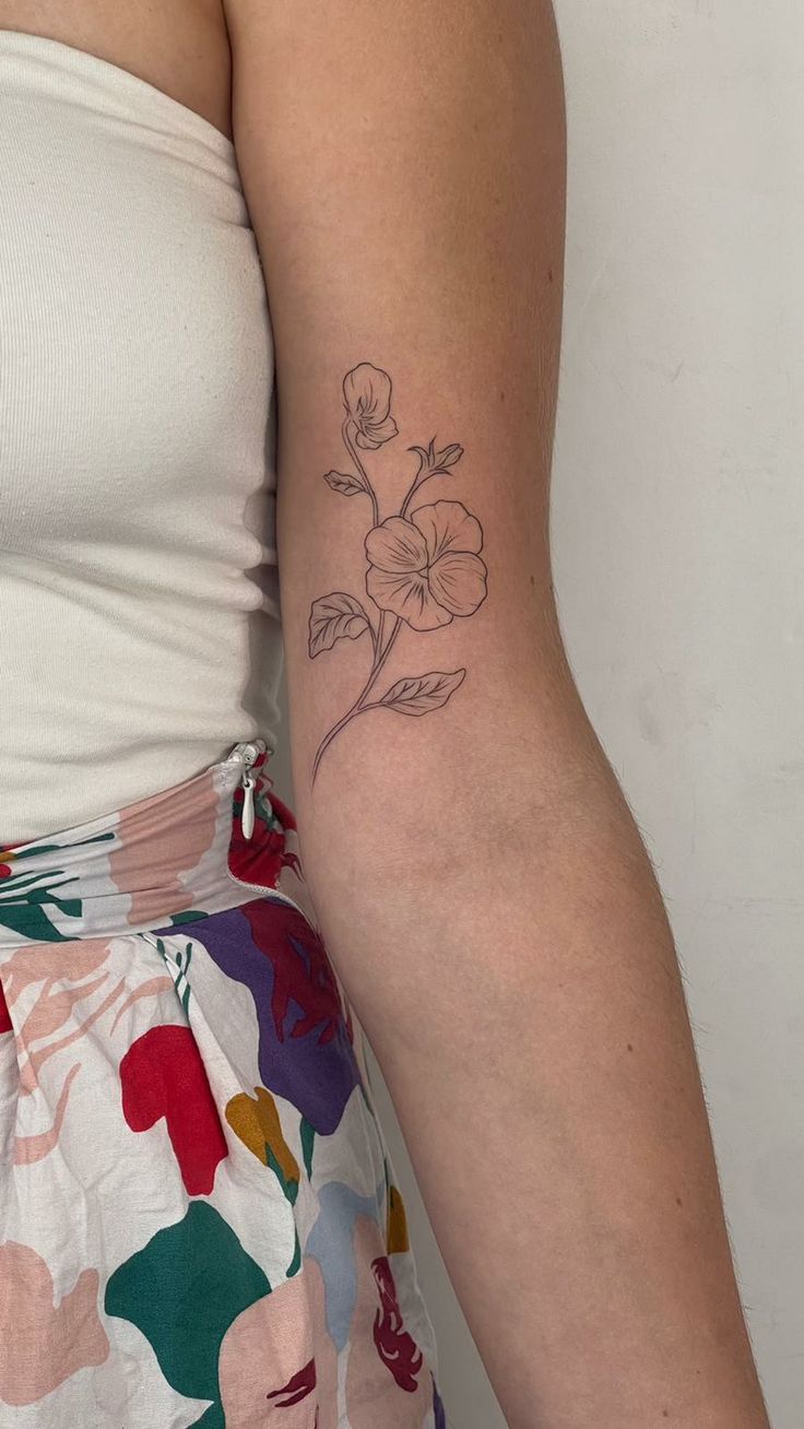 a woman with a flower tattoo on her arm