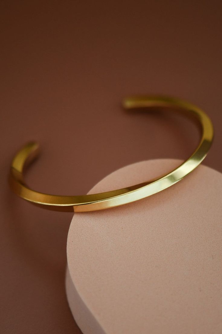 Ultimately simplistic with a unique curved design. This adjustable bangle bracelet is modern and shiny with a gorgeous twisted pattern. Gold dipped and made from a stainless steel metal. Adjustable Bracelet With A Modern Twist, Adjustable Stainless Steel Bangle With Polished Finish, Polished Stainless Steel Bangle Cuff Bracelet, Polished Stainless Steel Cuff Bracelet, Stainless Steel Polished Cuff Bracelet, Adjustable Stainless Steel Cuff Bracelet For Formal Occasions, Modern Twist Polished Bangle Cuff Bracelet, Adjustable Bangle With A Modern Twist, Adjustable Metal Cuff Bracelet With Polished Finish