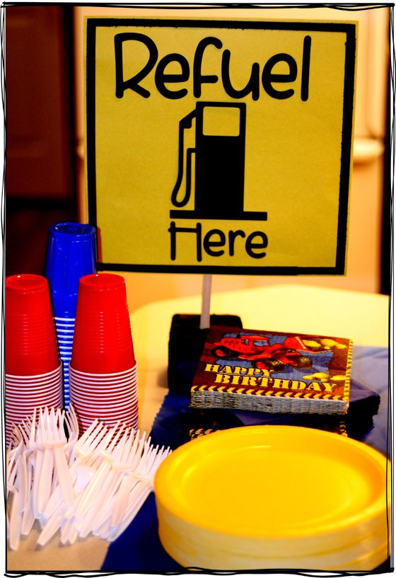 a table topped with plates and cups next to a sign that says refuel here