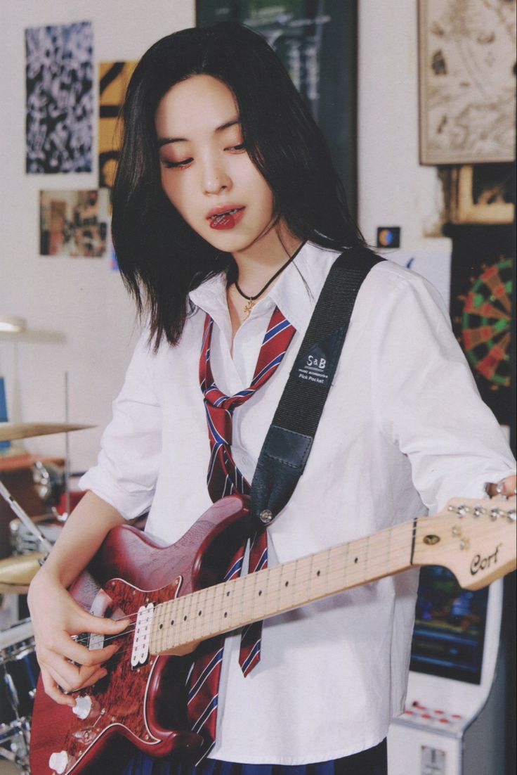 a young woman is playing an electric guitar