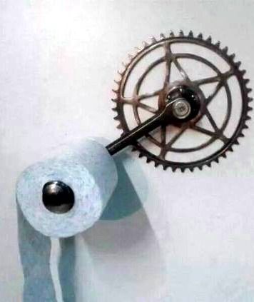 a toilet paper roll is hanging on the wall next to a spool of scissors