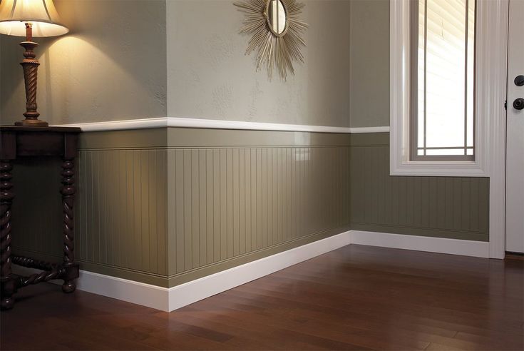 an empty room with wood flooring and a lamp on the side table in front of it