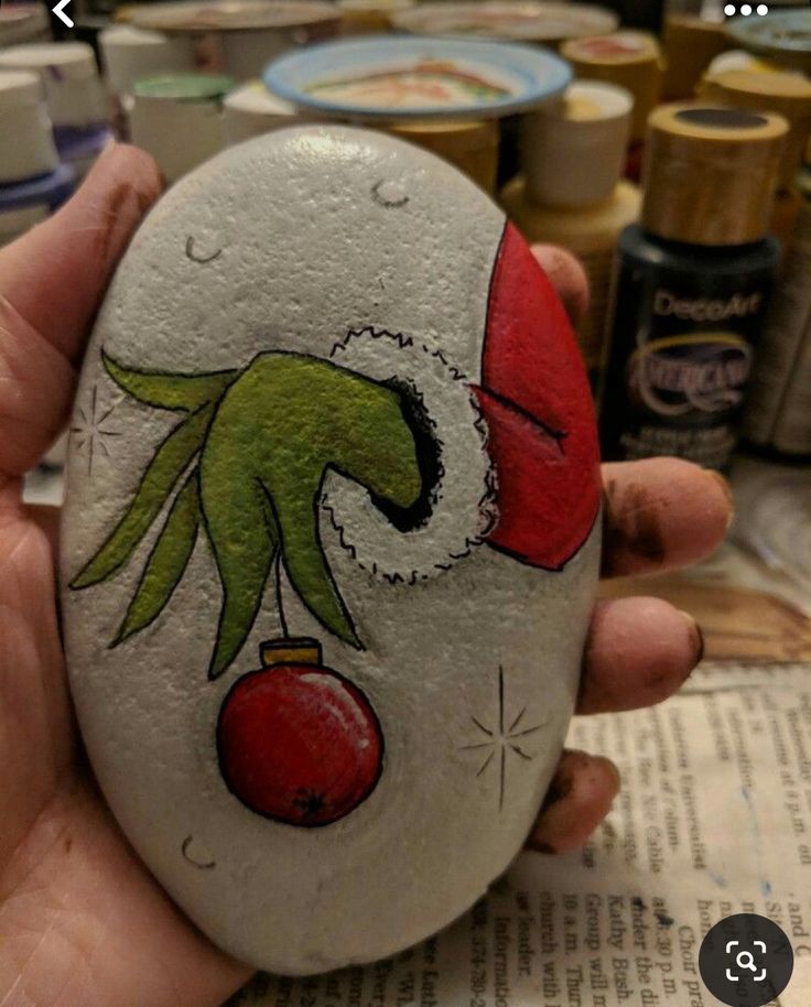 someone is holding up a painted rock in their hand