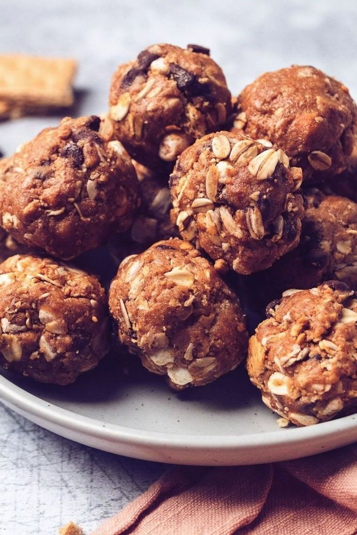 a plate filled with cookies and oats on top of a table next to crackers