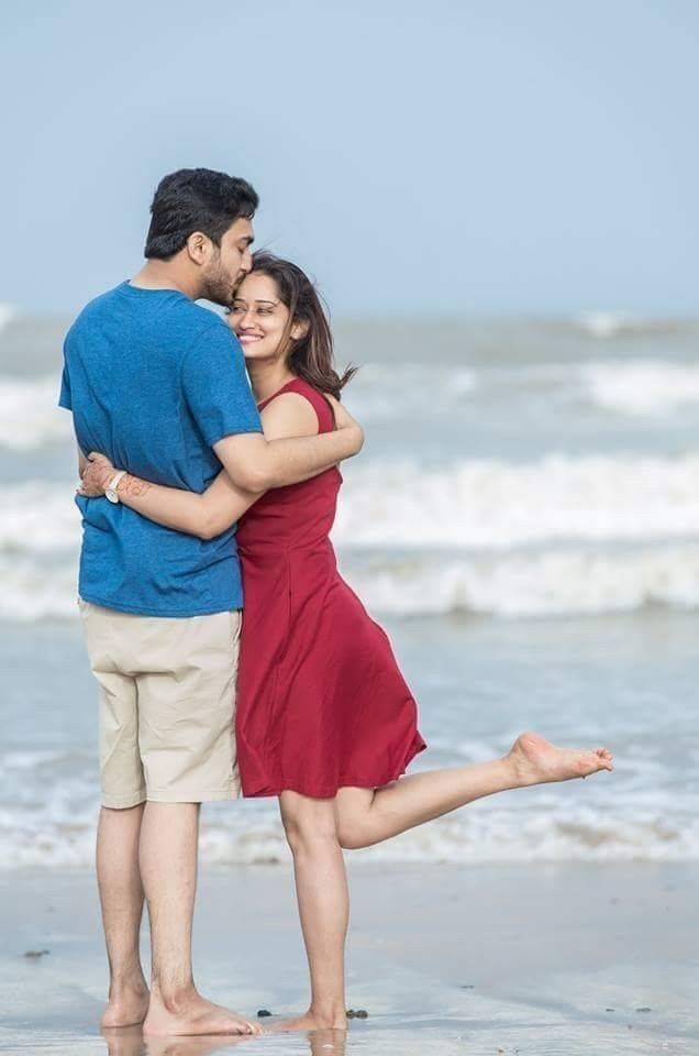 a man and woman embracing on the beach