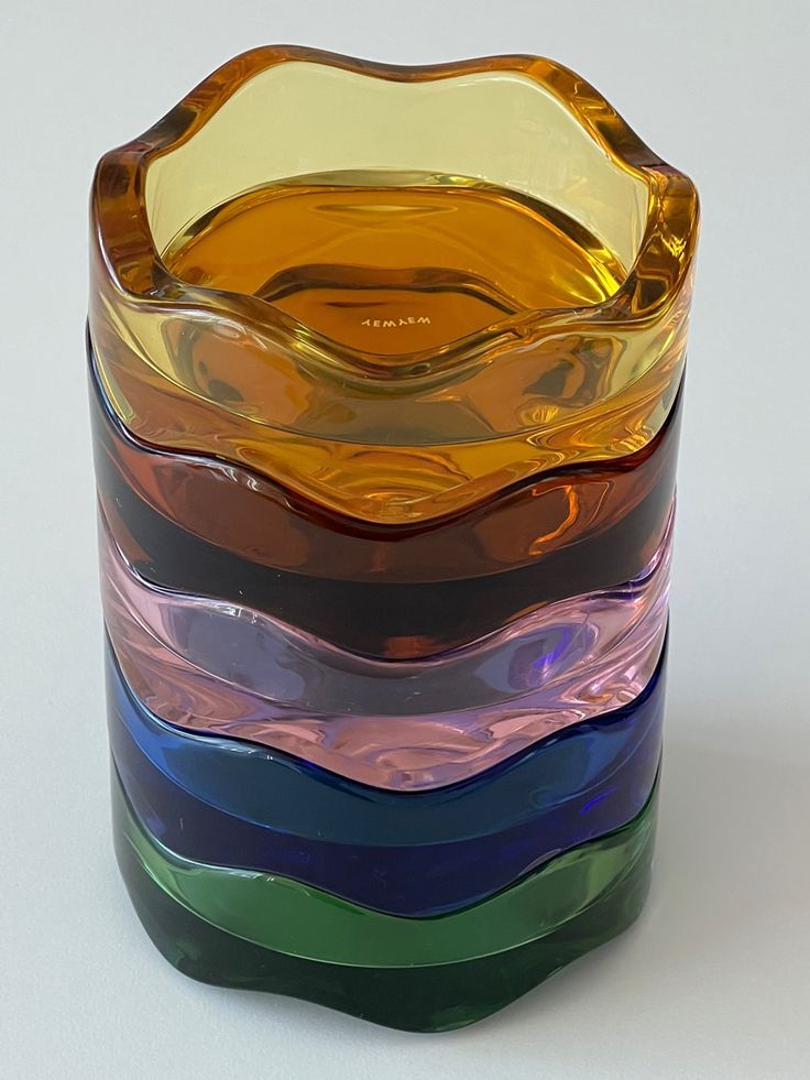 a stack of multicolored glass vases sitting on top of each other