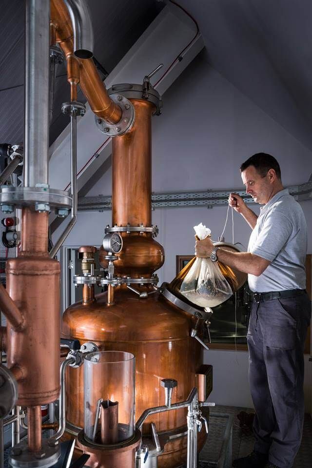 a man standing in front of some copper pipes