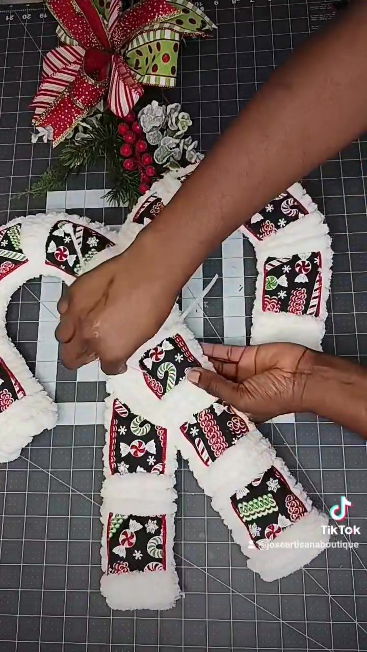 someone is cutting out the letters for their christmas wreath