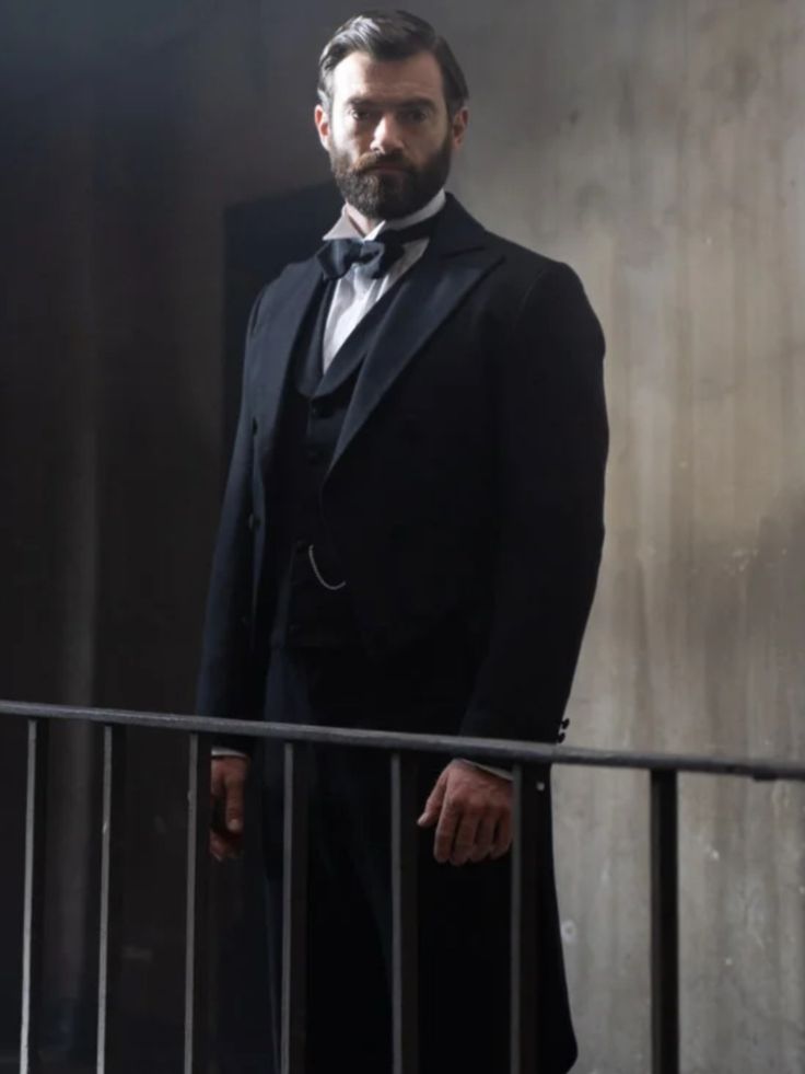 a man in a tuxedo standing on a balcony