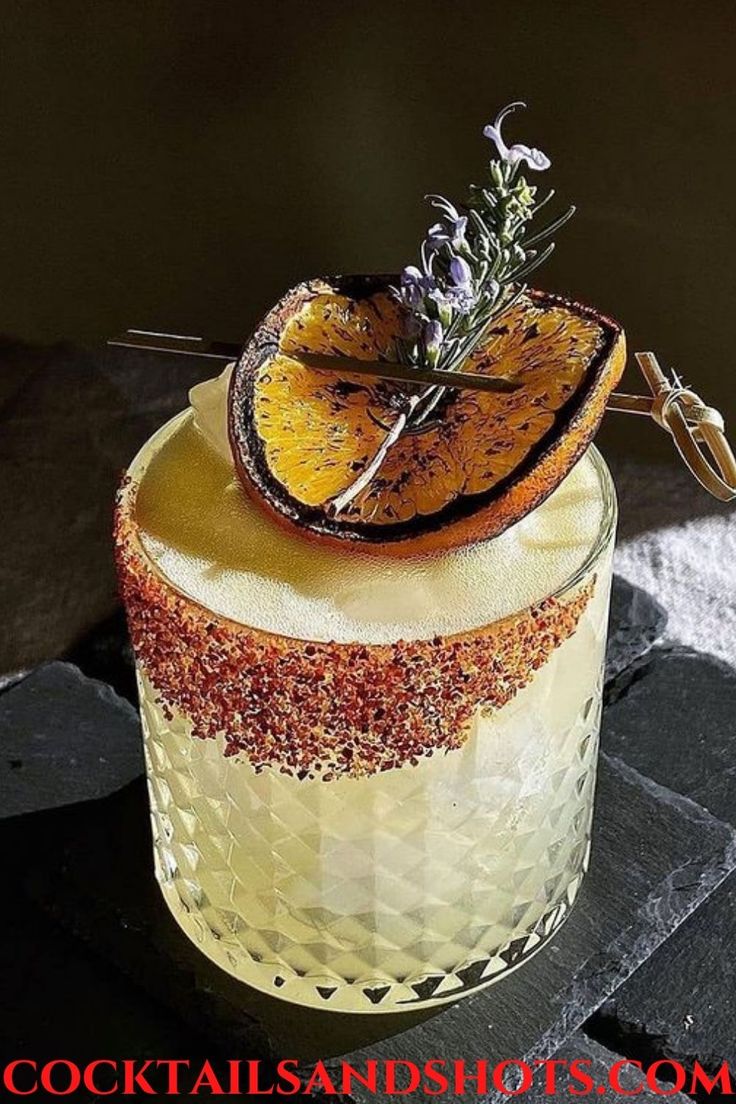 a dessert with orange slices and lavender sprigs on top is sitting on a table