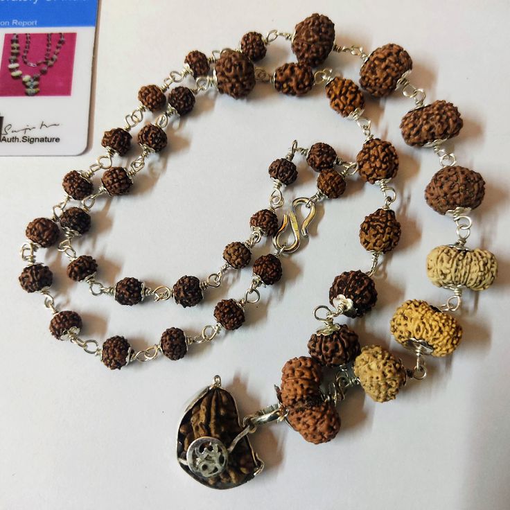 Product Name : Rudraksha Siddha Mala - Java Origin Lab Certified Configuration : 1 Mukhi Half moon Shape  : 25 mm 2 Mukhi  , 3 Mukhi :  7 mm - 8 mm 4 Mukhi , 6 Mukhi , 7 Mukhi , 8 Mukhi   : 9 mm - 10 mm 9 mukhi , 10 mukhi , 11 mukhi , 12 mukhi , 13 mukhi , 14 mukhi : 10 mm - 14 mm Gauri shankar : 12 mm - 13 mm Ganesh Rudraksha : 15 mm Rest are Rudraksha 5 mukhi beads size - 8 mm  Lab Certified - You will get card of Lab certification. WITH PURE SILVER CAP Significance : * This is an "Akshamalika Silver Spiritual Mala For Puja, Festive Multicolor Spiritual Temple Necklace, Silver Mala For Puja And Diwali, Silver Mala For Puja During Diwali, Silver Mala For Puja On Diwali, Silver Mala For Diwali Puja, Silver Spiritual Mala For Festivals, Navratri Puja Cutdana Mala, Handmade Multicolor Temple Necklace For Puja