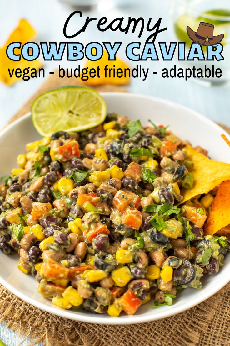 a white bowl filled with black beans, corn and guacamole next to tortilla chips