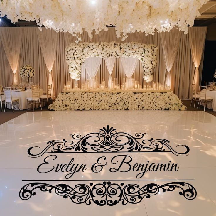 the dance floor is decorated with white flowers and black lettering that says evelyn & begun