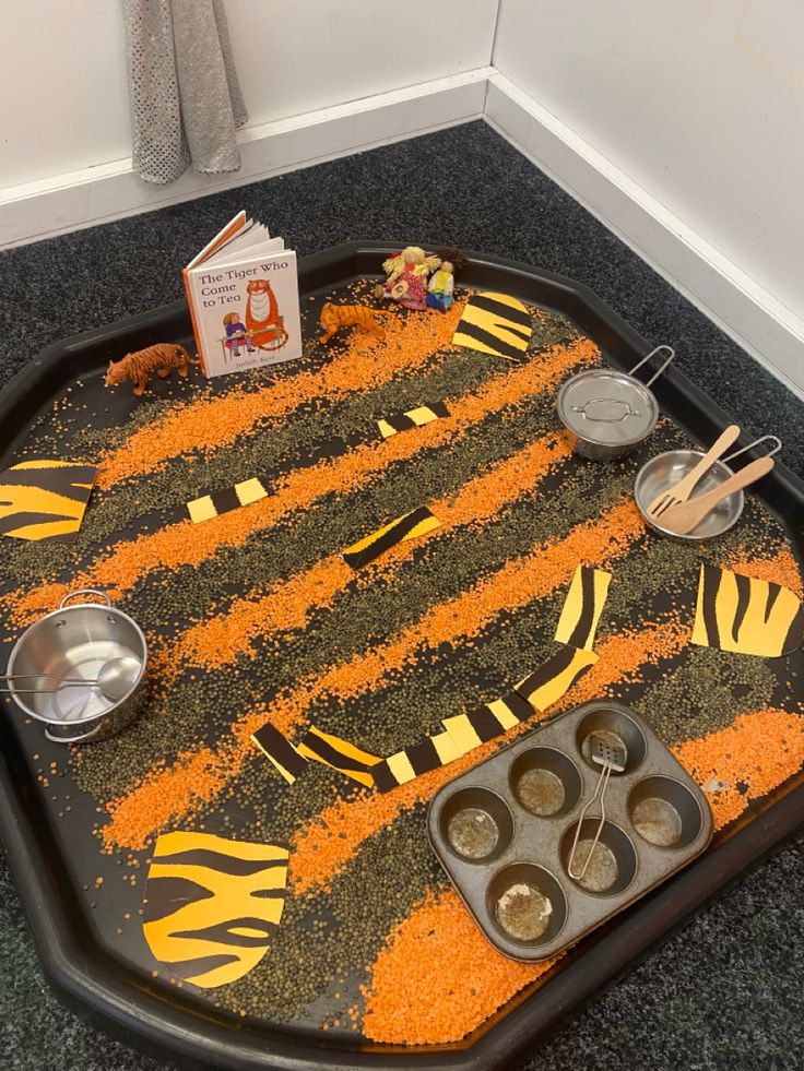 the tray is made to look like it has orange and black stripes on it, with cupcakes in them