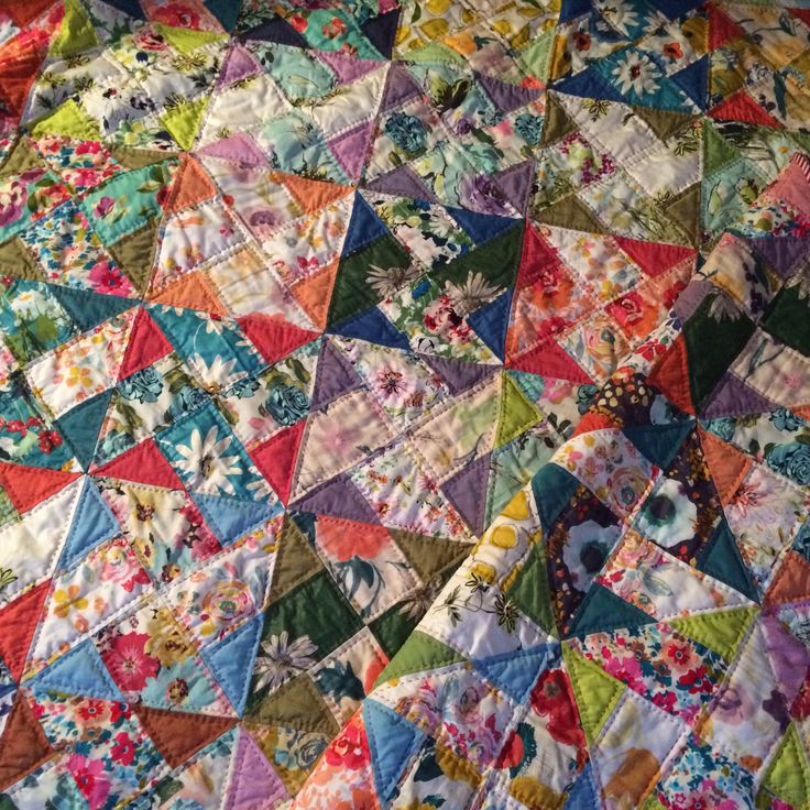 a colorful quilt is laying on the floor