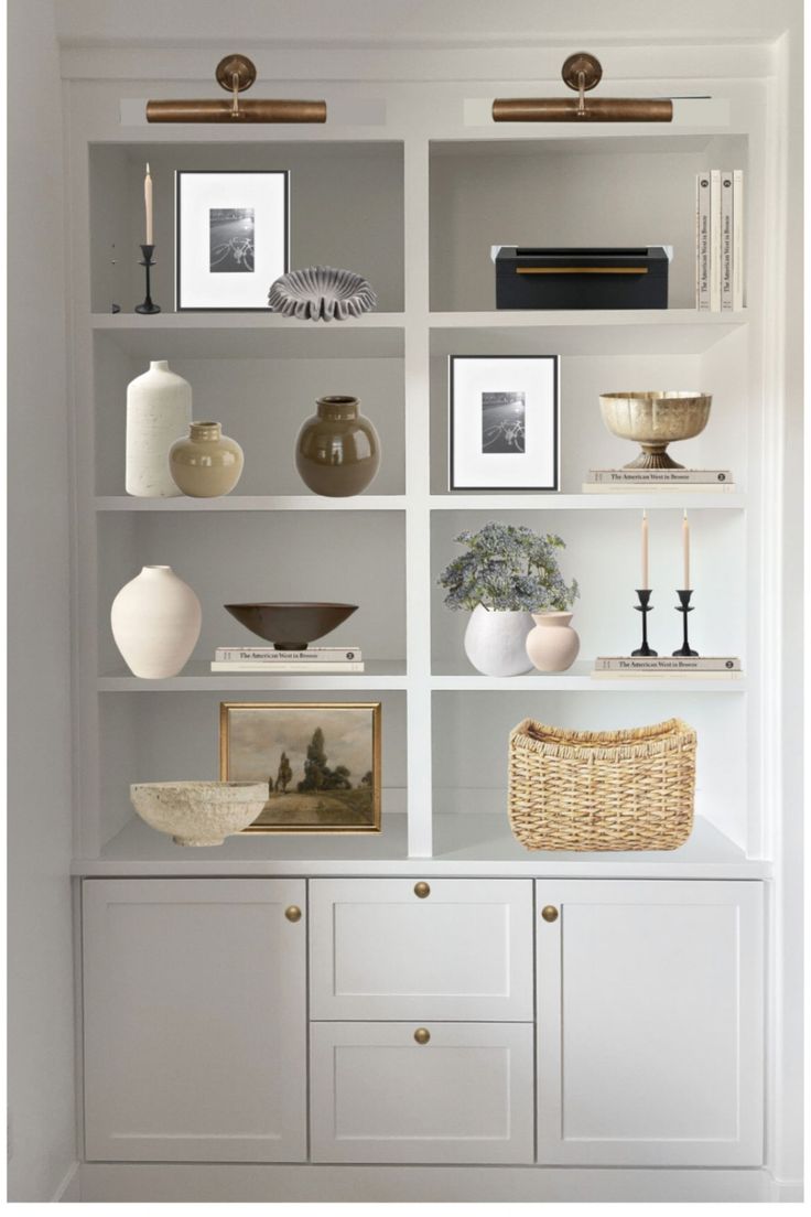 a white bookcase with pictures and vases on it's shelves in a room