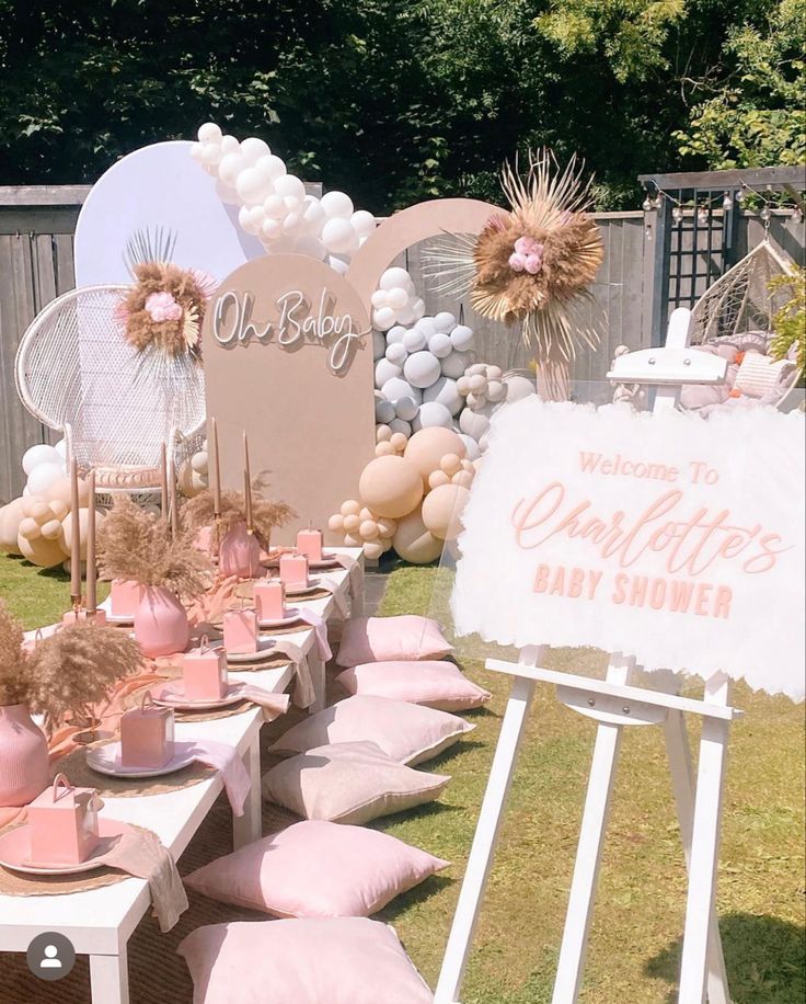 a baby shower is set up outside on the grass with balloons and decorations around it